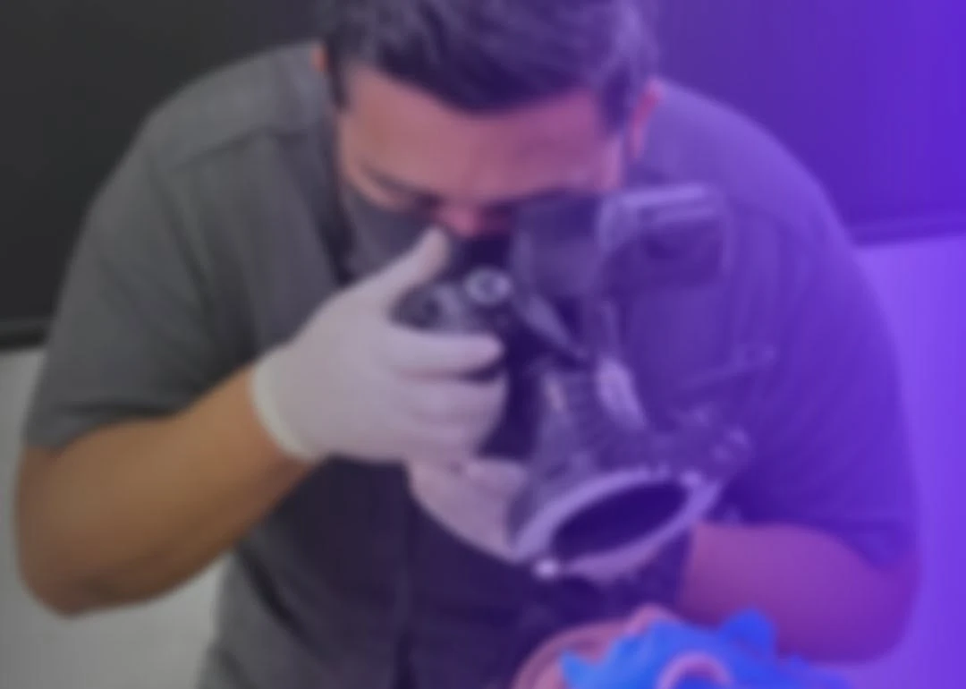 Odontólogo tomando una fotografía a una paciente con separador bucal